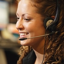 Close up, profile shot of a smiling professional woman taking a phone call on her headset
